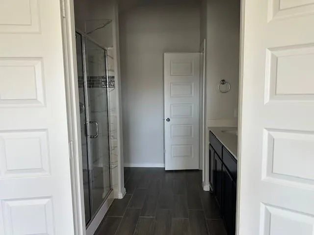 an empty room with wooden floor and ceiling fan