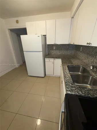 a kitchen with a sink a stove top oven and cabinets