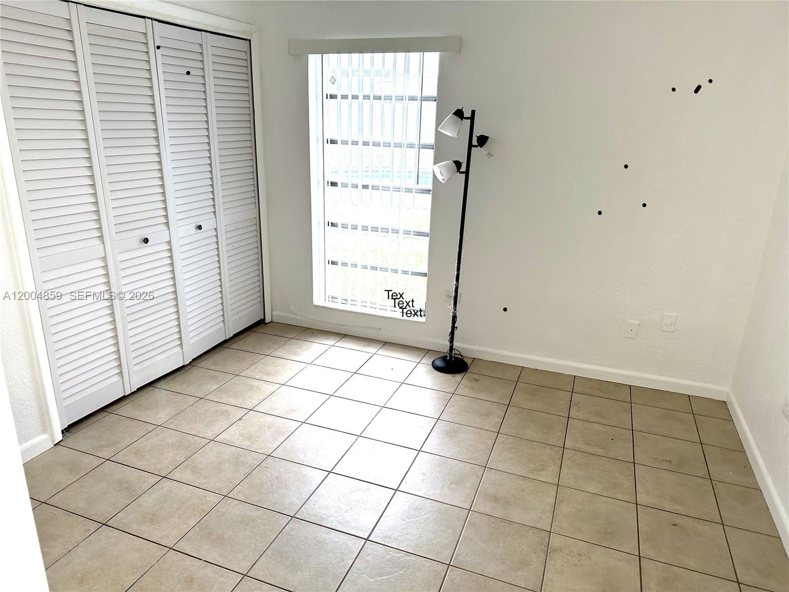 7256 Southwest 94th Place, Unit A4 Miami, FL 33173 - Photo 12 of 18 an empty room with white walls and tiles