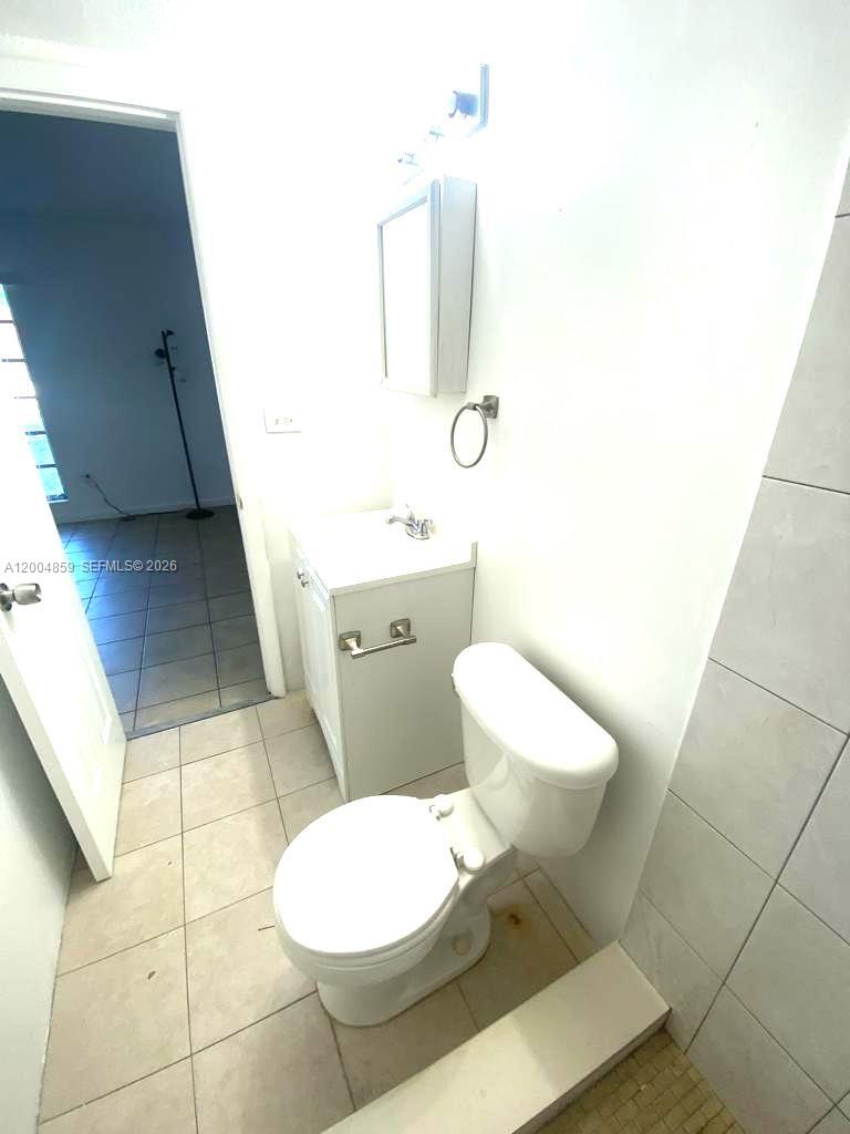 7256 Southwest 94th Place, Unit A4 Miami, FL 33173 - Photo 13 of 18 a bathroom with a toilet sink and mirror