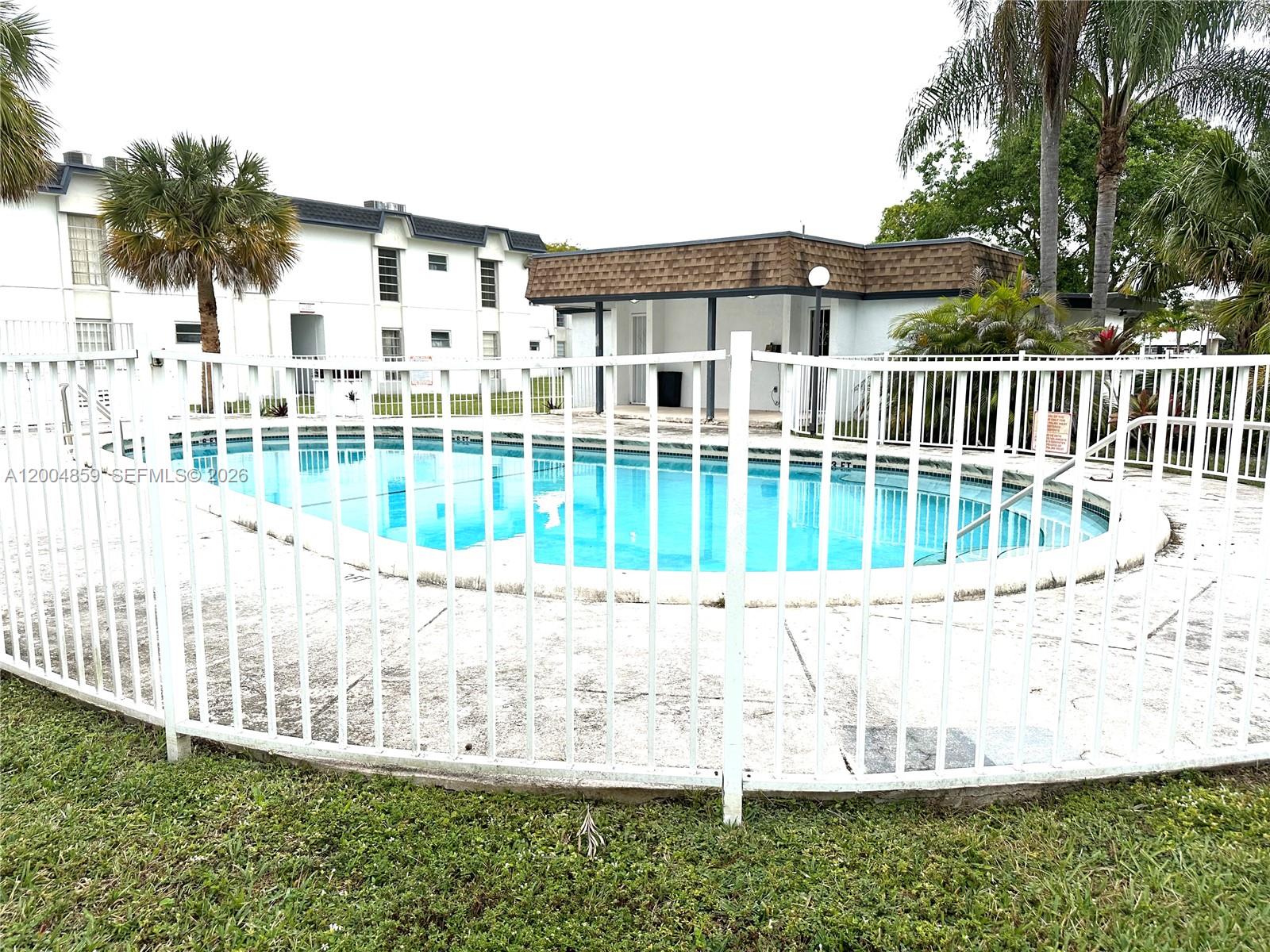 7256 Southwest 94th Place, Unit A4 Miami, FL 33173 - Photo 18 of 18 a view of a house with a yard and fence