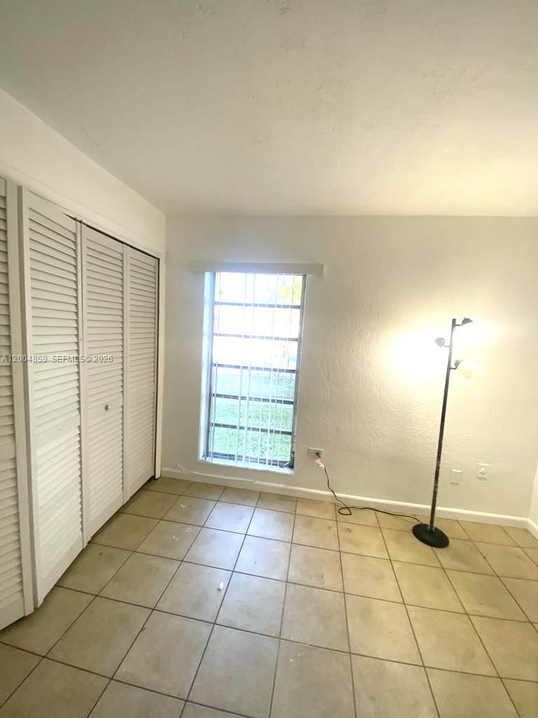 7256 Southwest 94th Place, Unit A4 Miami, FL 33173 - Photo 9 of 18 a view of an empty room with a window