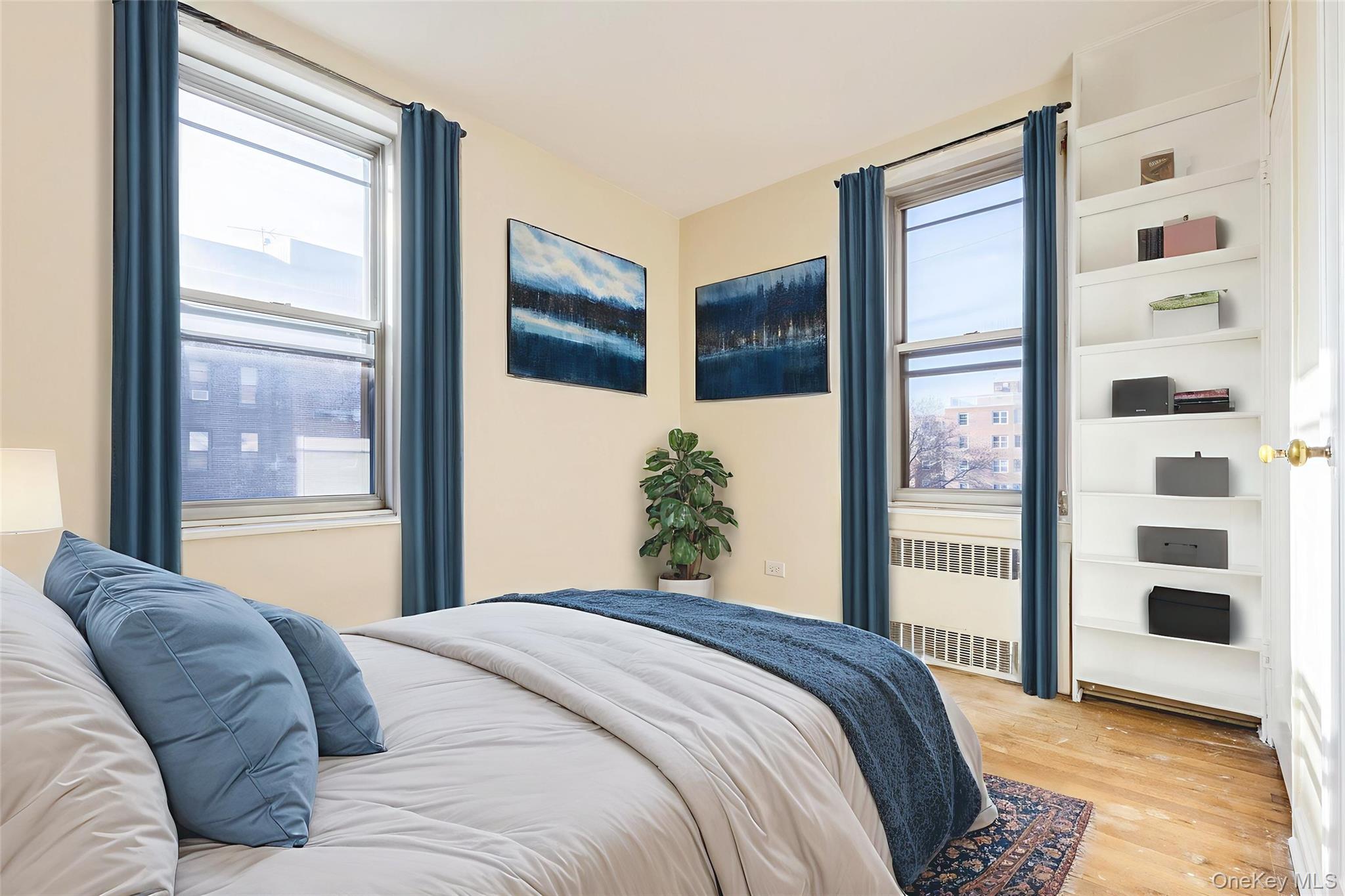 2232 Brigham Street, Unit EE4 Brooklyn, NY 11229 - Photo 12 of 16 Bedroom featuring radiator heating unit, light wood-style floors, and multiple windows