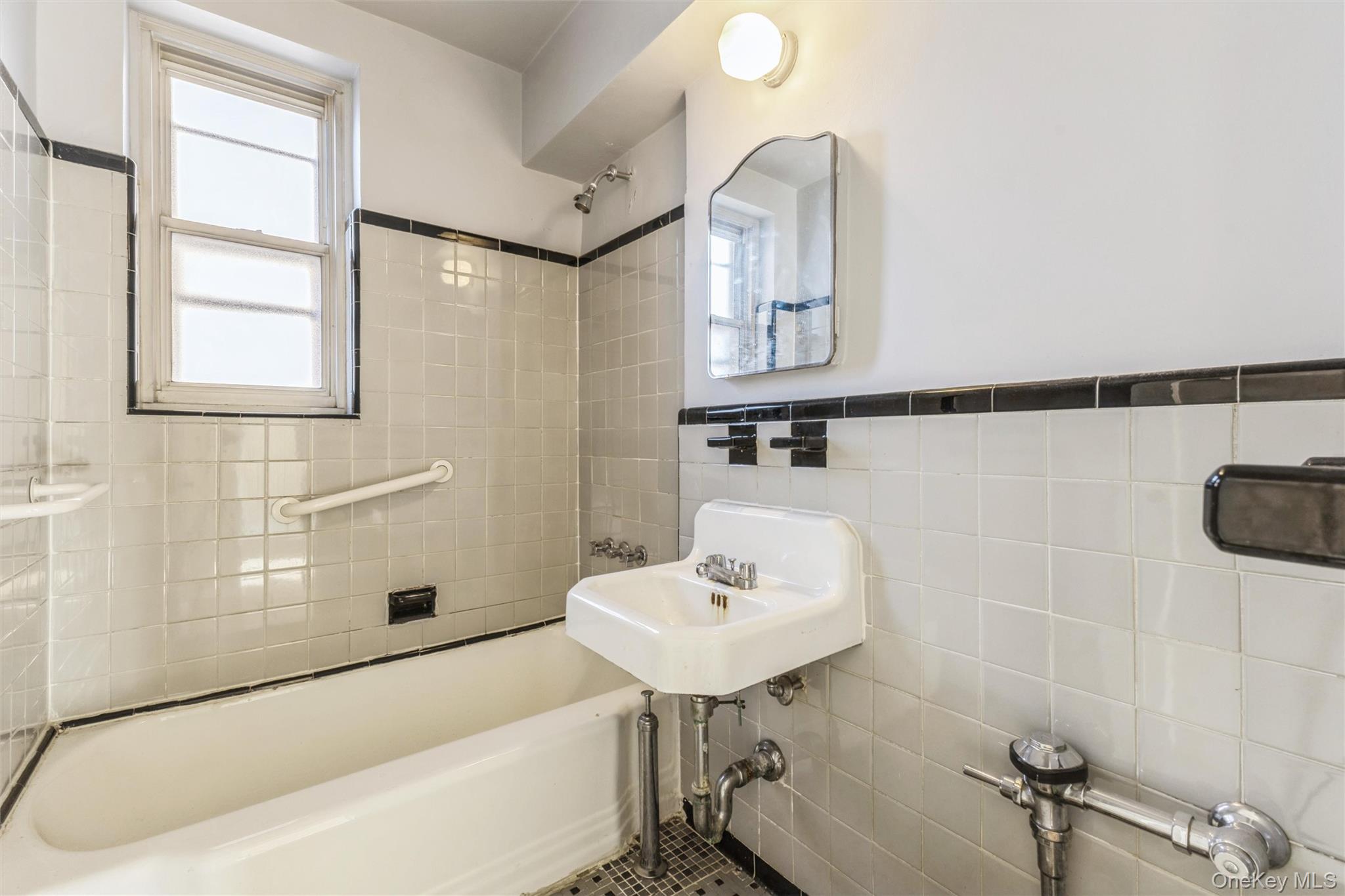 2232 Brigham Street, Unit EE4 Brooklyn, NY 11229 - Photo 14 of 16 Full bath featuring shower / washtub combination, tile walls, healthy amount of natural light, and wainscoting