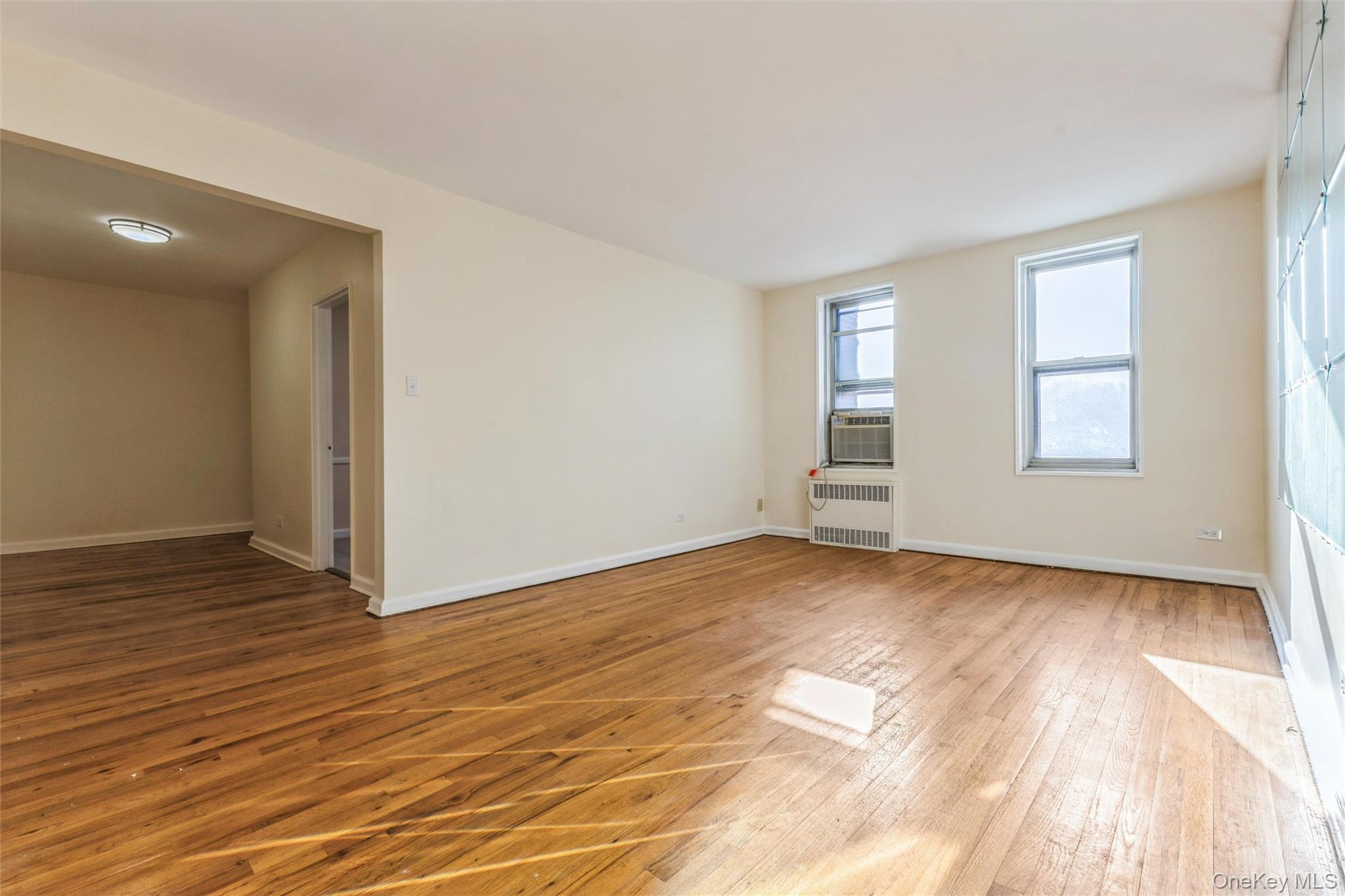 2232 Brigham Street, Unit EE4 Brooklyn, NY 11229 - Photo 2 of 16 Spare room with light wood-style flooring and radiator