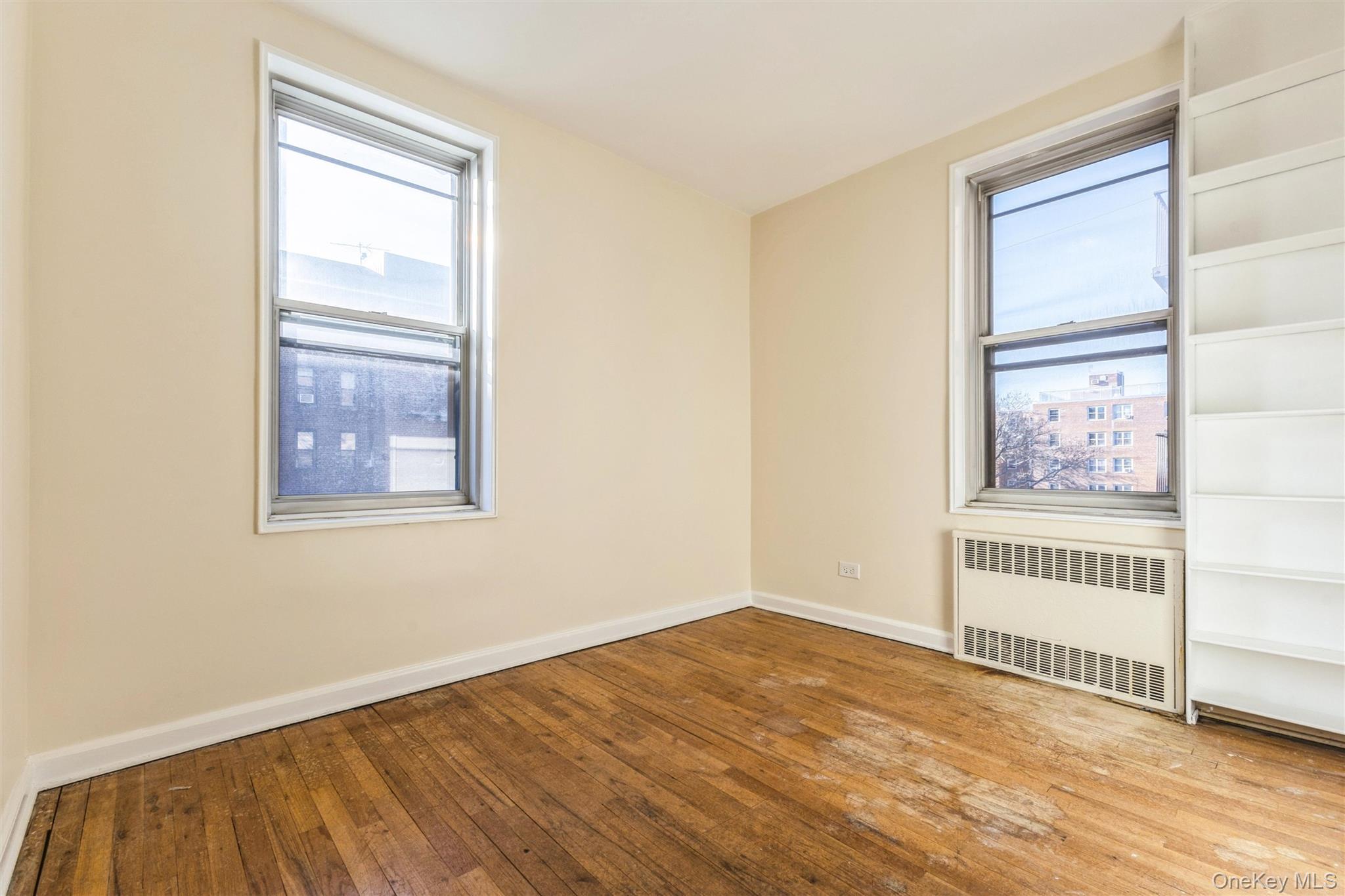 2232 Brigham Street, Unit EE4 Brooklyn, NY 11229 - Photo 9 of 16 Unfurnished room featuring radiator, hardwood / wood-style floors, and plenty of natural light