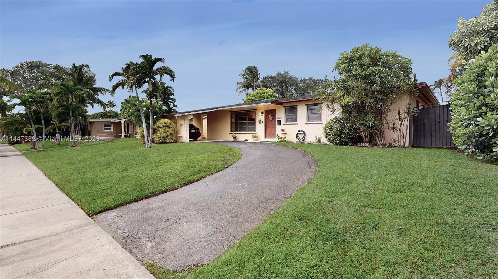a front view of a house with a yard and potted plants
