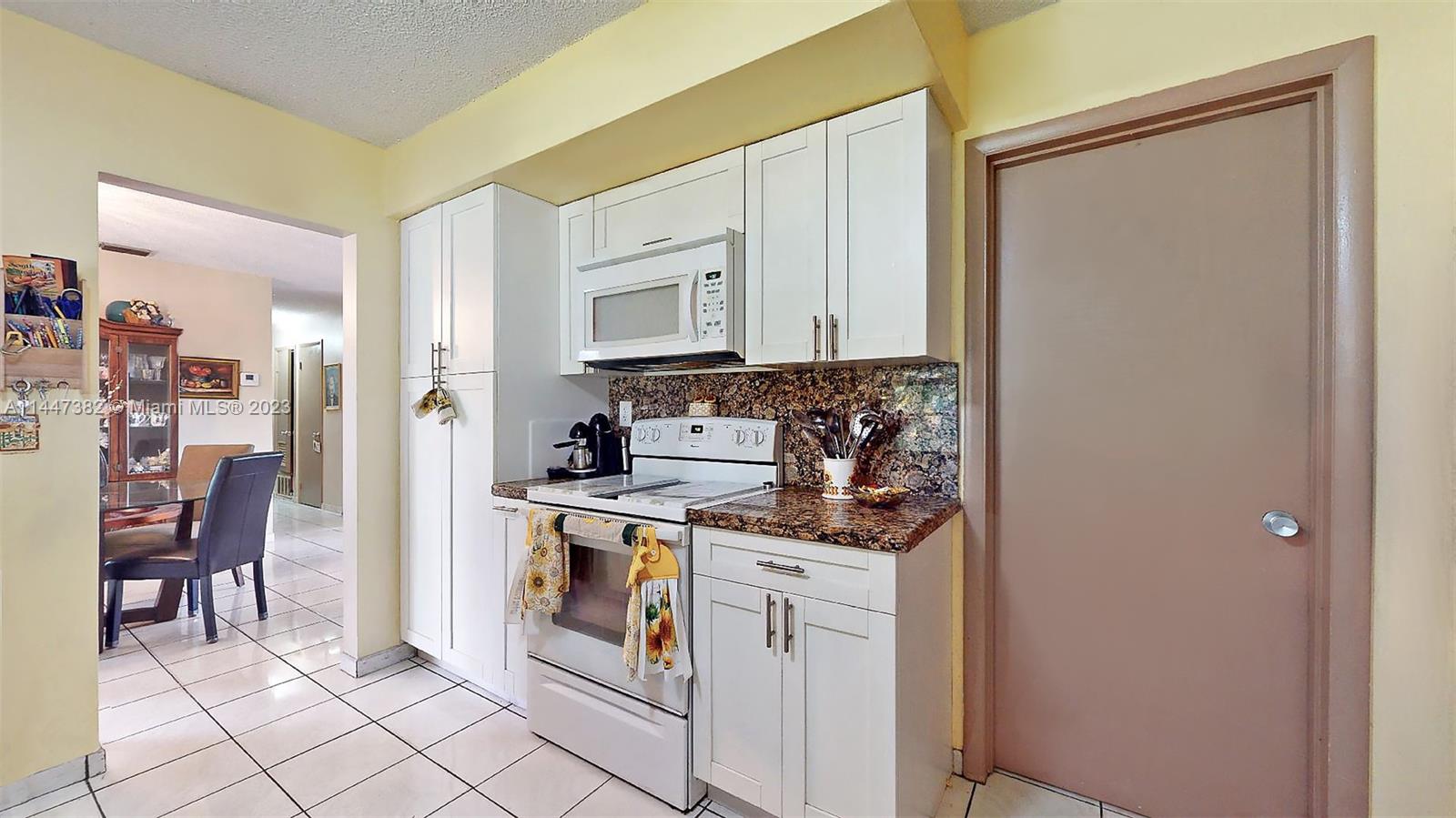 9815 Southwest 77th Street Miami, FL 33173 - Photo 12 of 30 a kitchen with a stove a sink and a refrigerator