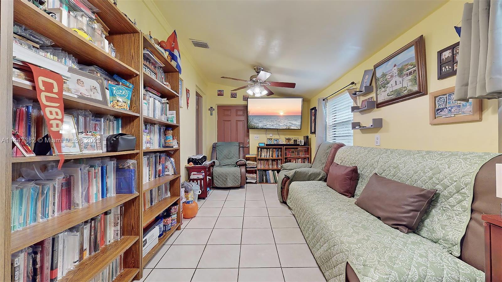 9815 Southwest 77th Street Miami, FL 33173 - Photo 16 of 30 a living room with furniture a book shelf and a book shelf