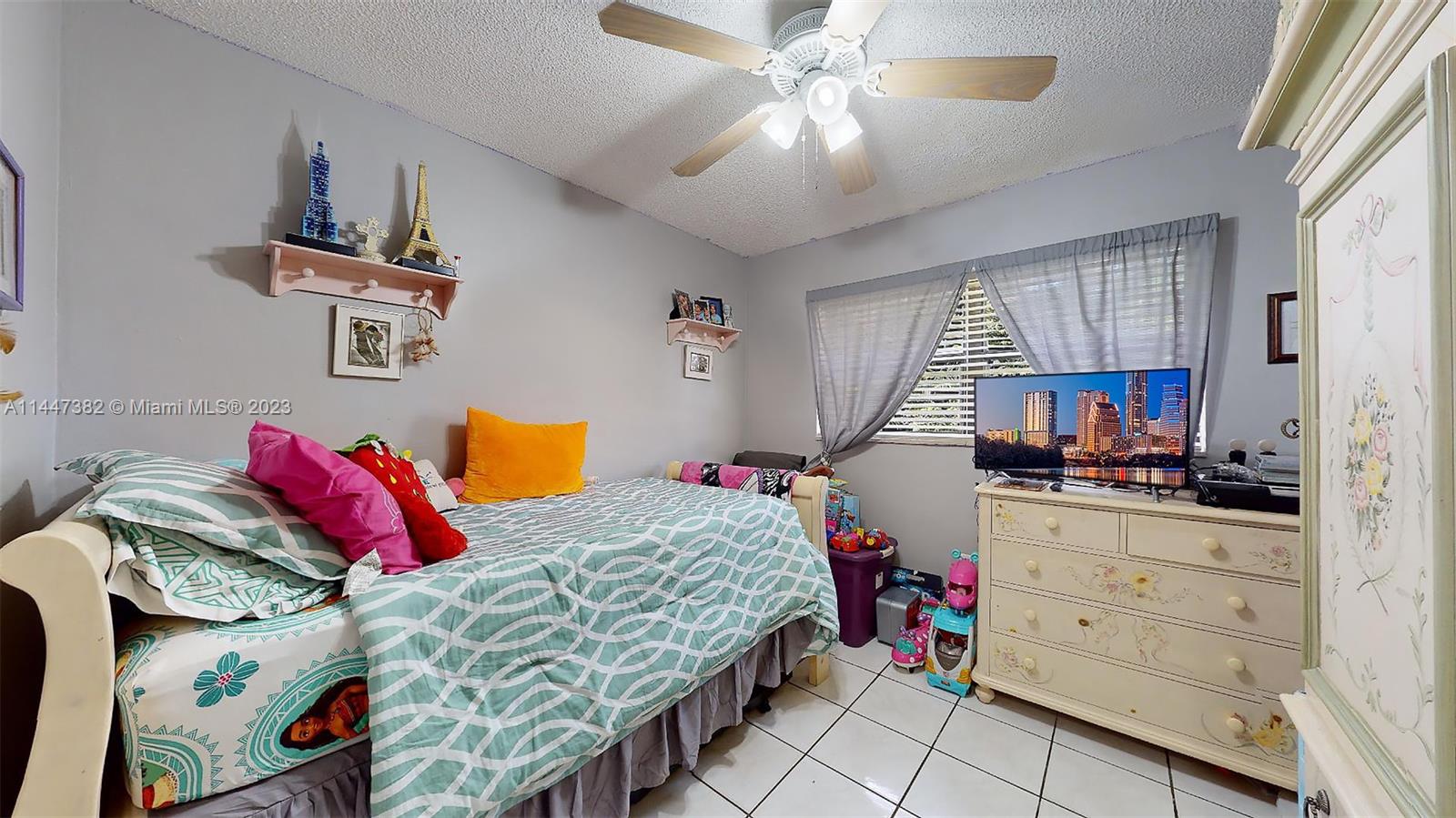 9815 Southwest 77th Street Miami, FL 33173 - Photo 17 of 30 a bedroom with a bed and a chandelier