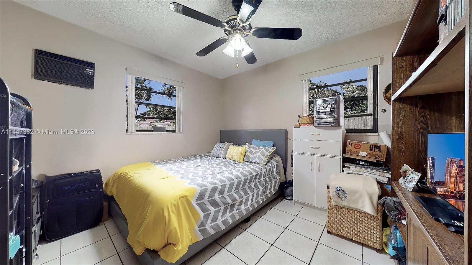 9815 Southwest 77th Street Miami, FL 33173 - Photo 18 of 30 a bedroom with a bed and a chandelier