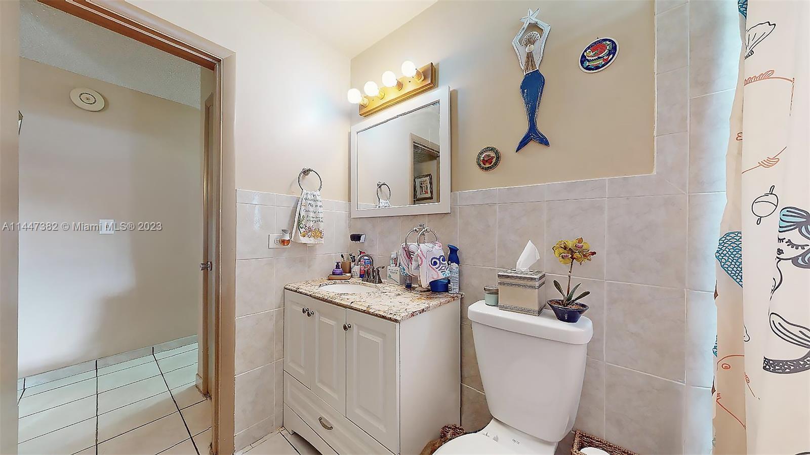9815 Southwest 77th Street Miami, FL 33173 - Photo 20 of 30 a bathroom with a sink mirror vanity and toilet