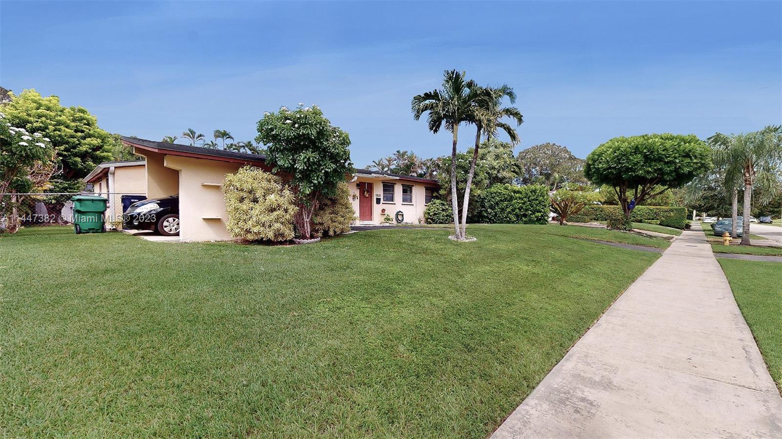 9815 Southwest 77th Street Miami, FL 33173 - Photo 3 of 30 a front view of a house with a yard and palm trees