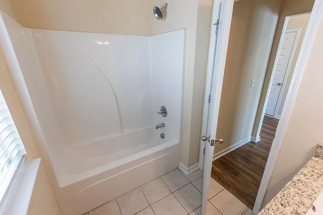 a kitchen with stainless steel appliances granite countertop a refrigerator a sink dishwasher a stove and white countertops with wooden floor