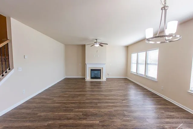 a view of empty room with wooden floor and fireplace