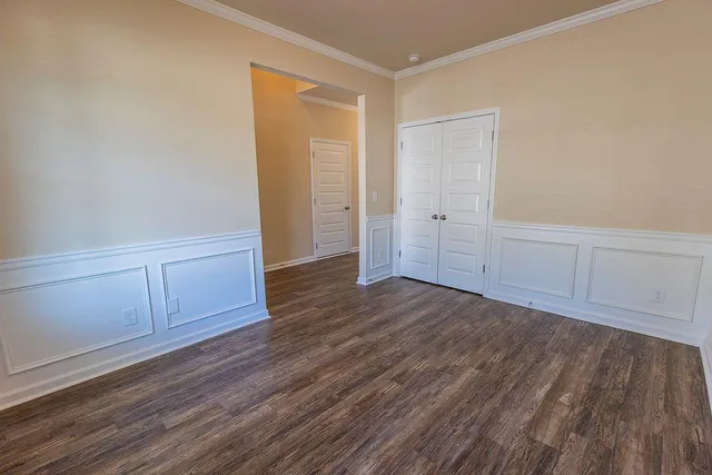 a view of an empty room with wooden floor and cabinet