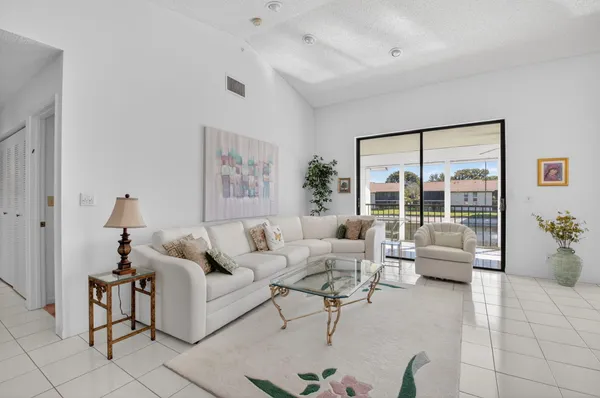 a living room with furniture and floor to ceiling window