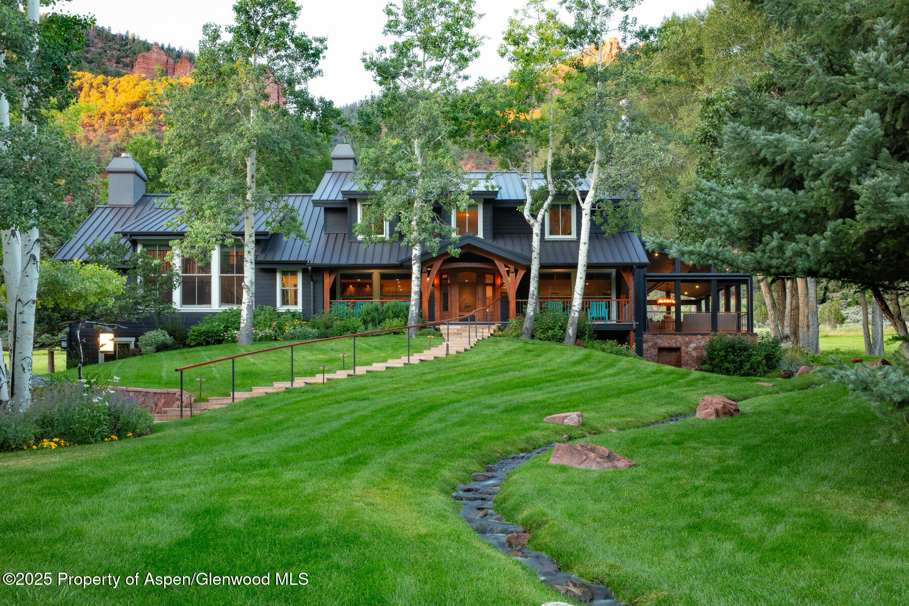 2147 Lower River Road Snowmass, CO 81654 - Photo 1 of 61 a front view of a house with a yard table and chairs