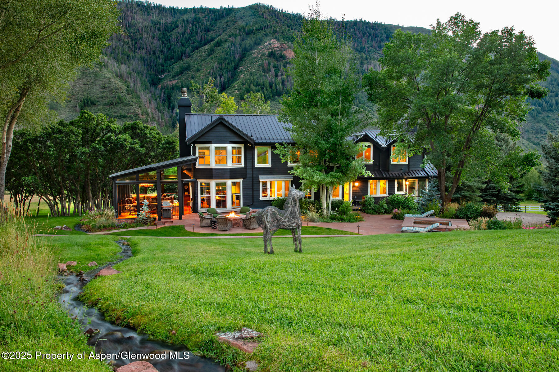 2147 Lower River Road Snowmass, CO 81654 - Photo 4 of 61 a front view of a house with a yard table and chairs