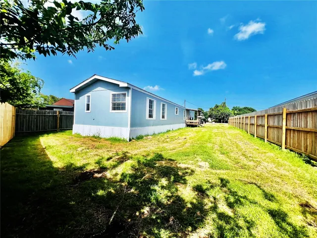 a blue swimming pool is in a backyard of a house