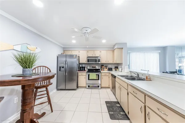 a kitchen with stainless steel appliances kitchen island granite countertop a refrigerator a stove a sink a dining table and chairs