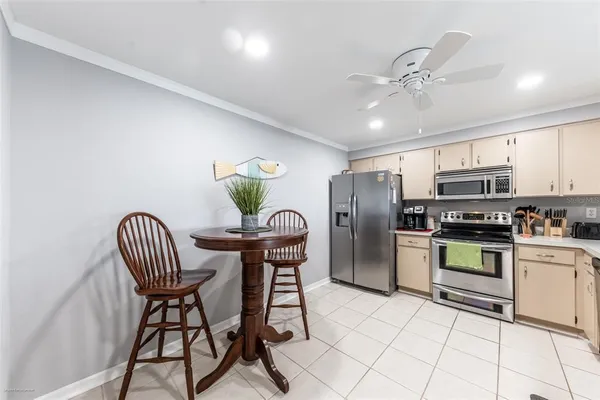 a kitchen with stainless steel appliances kitchen island granite countertop a refrigerator a stove a microwave oven with a dining table and chairs