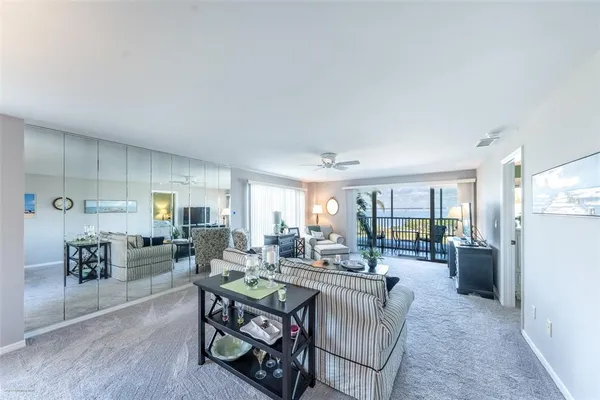 a living room with furniture a large window and stainless steel appliances