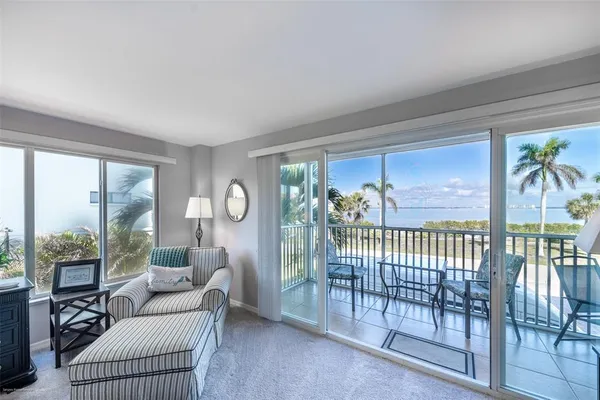 a living room with furniture a fireplace and a floor to ceiling window