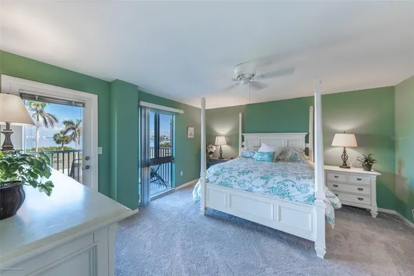 a bedroom with a large bed and a potted plant