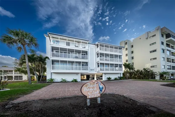 a front view of a building with a garden and plants