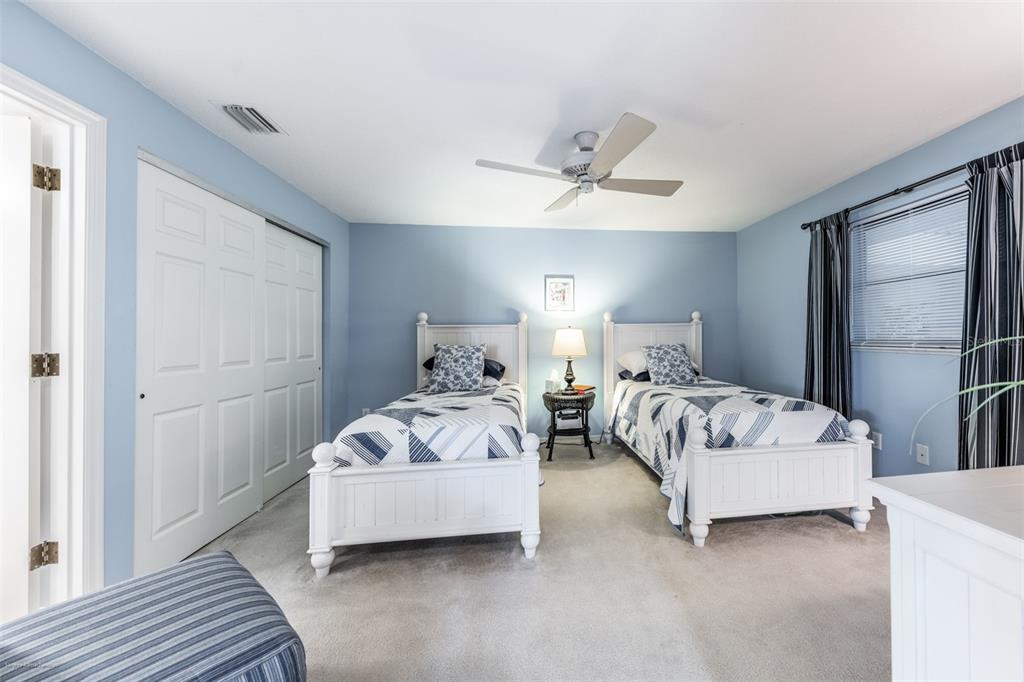 1477 Park Beach Circle, Unit 11 Punta Gorda, FL 33950 - Photo 41 of 49 a bedroom with a bed and a ceiling fan