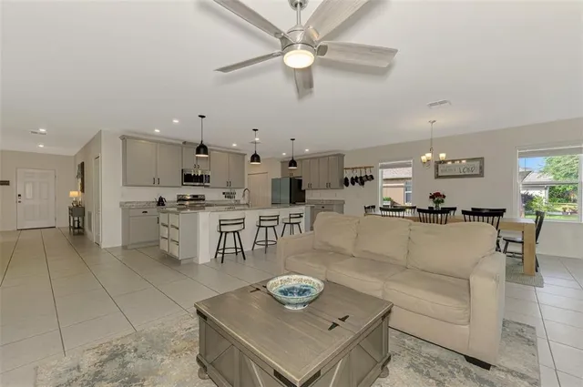 a living room with stainless steel appliances kitchen island a table and chairs