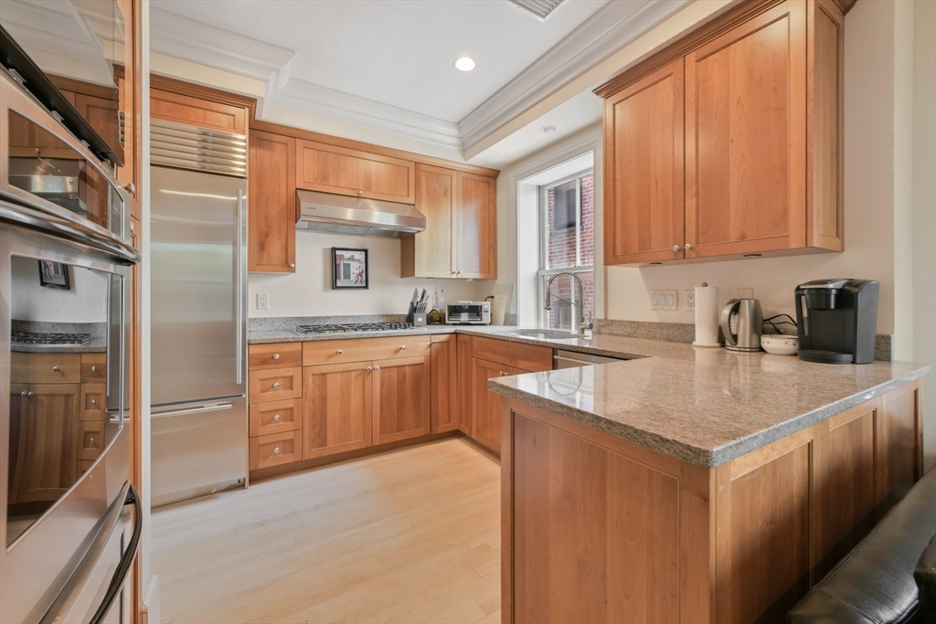 294 Commonwealth Avenue, Unit 2 Boston, MA 02115 - Photo 11 of 26 a kitchen with stainless steel appliances granite countertop a sink stove and refrigerator