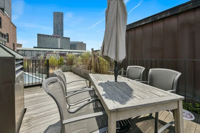 a roof deck with a table and chairs