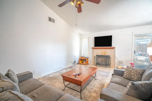 a living room with furniture a flat screen tv and a fireplace