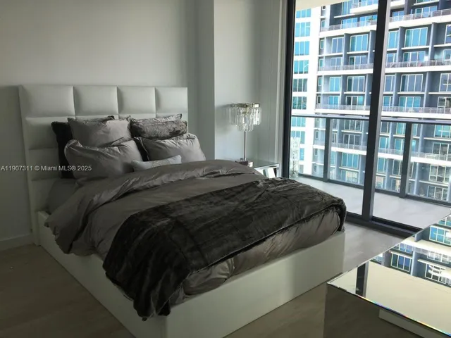 a bedroom with a bed next to a window