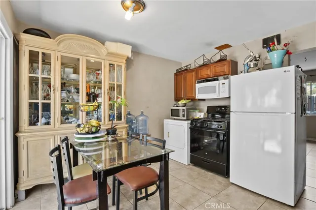 a kitchen with granite countertop a refrigerator and a stove top oven