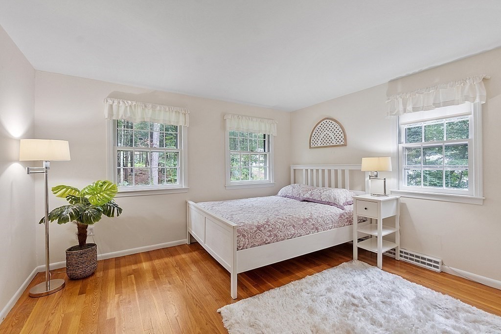 100 Chester Road Boxborough, MA 01719 - Photo 32 of 40 a bedroom with a bed windows and a chandelier