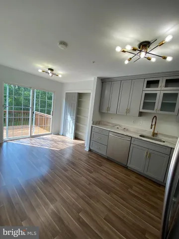 a kitchen with stainless steel appliances granite countertop a sink dishwasher stove and wooden floors with granite countertops