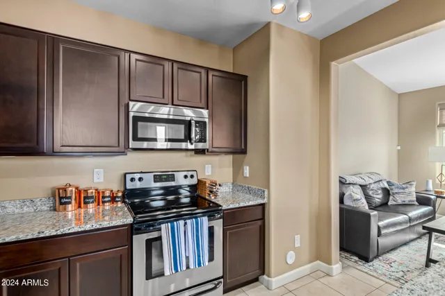 a kitchen with stainless steel appliances granite countertop a stove a sink and a microwave