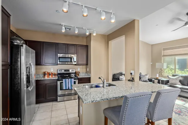 a kitchen with stainless steel appliances granite countertop a stove a sink a refrigerator and a refrigerator