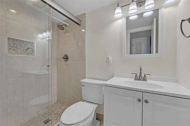 a bathroom with a sink a toilet a mirror and shower