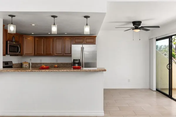 a kitchen with stainless steel appliances kitchen island granite countertop a refrigerator and a sink