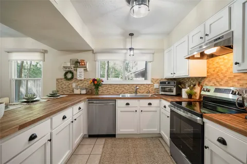 a kitchen with a white cabinets and window