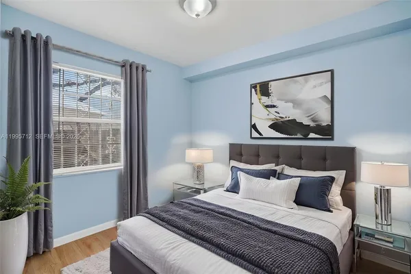 a bedroom with a bed and a painting on the wall