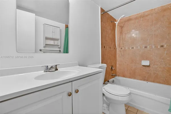 a bathroom with a sink a toilet a mirror and shower