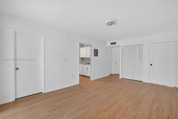 a view of empty room with wooden floor