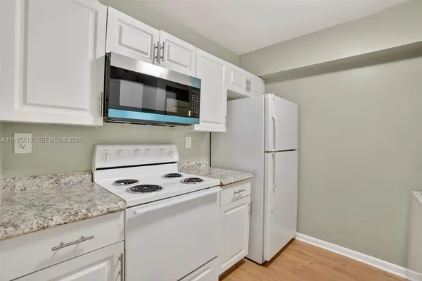 a kitchen with granite countertop cabinets stainless steel appliances and a counter space