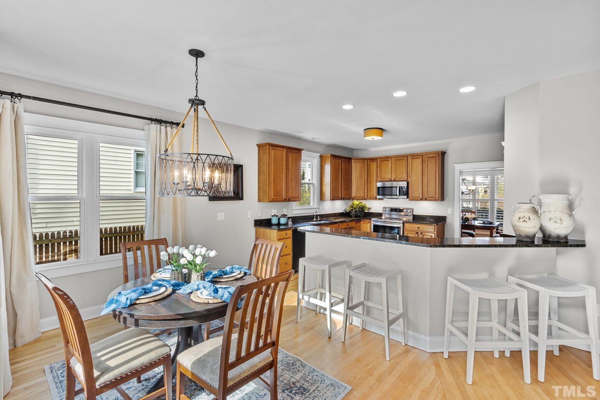 145 Kingsport Road Holly Springs, NC 27540 - Photo 13 of 42 a view of a dining room and livingroom with furniture wooden floor a chandelier