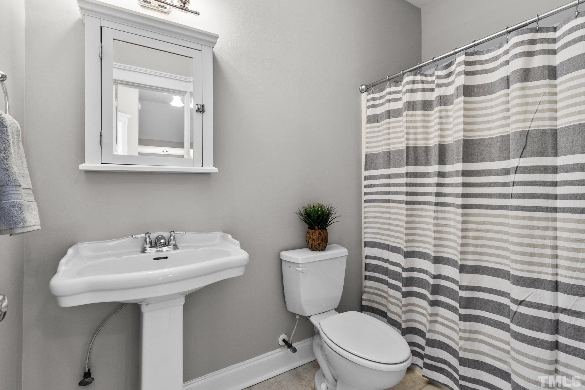 145 Kingsport Road Holly Springs, NC 27540 - Photo 20 of 42 a bathroom with a sink a toilet and mirror